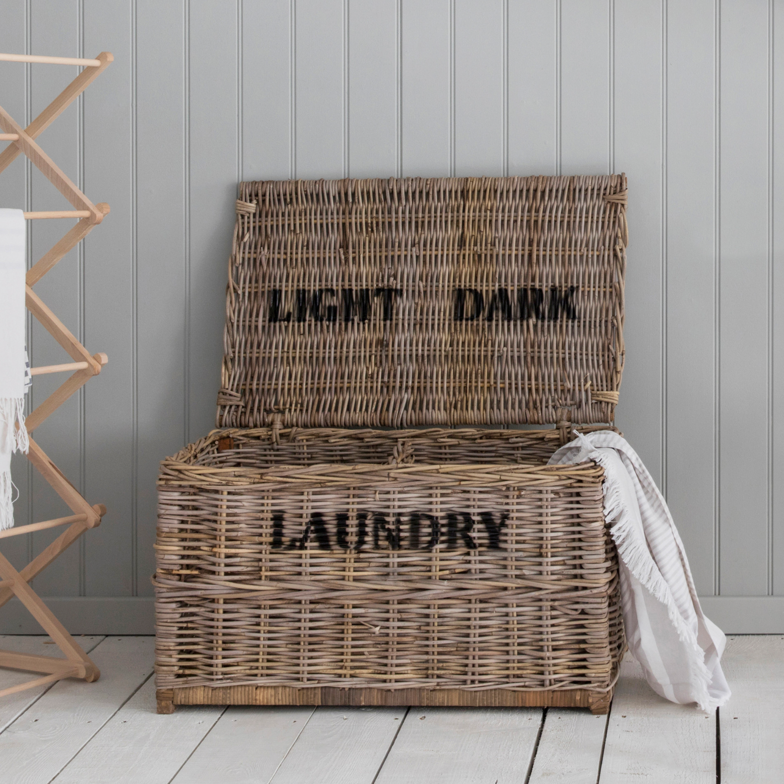 Rattan laundry basket with light and dark labels.