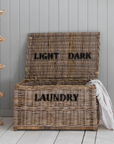 Rattan laundry basket with light and dark labels.