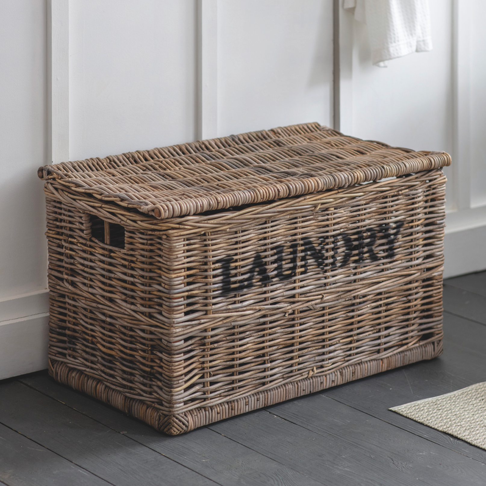 Rattan laundry basket with light and dark labels.