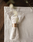 Pinstripe napkin in a brass napkin ring, on matching placemat.