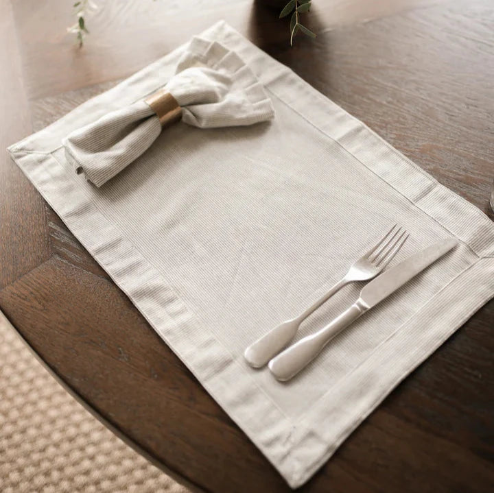 Charcoal and white pinstripe cotton placemat in dark table with cutlery and napkin in napkin ring.