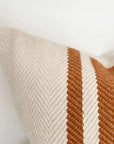 Close up of rust and cream striped cushion.