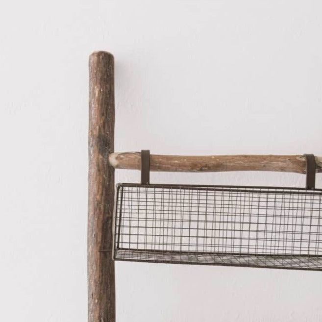 Close up of wire basket on wooden storage ladder.