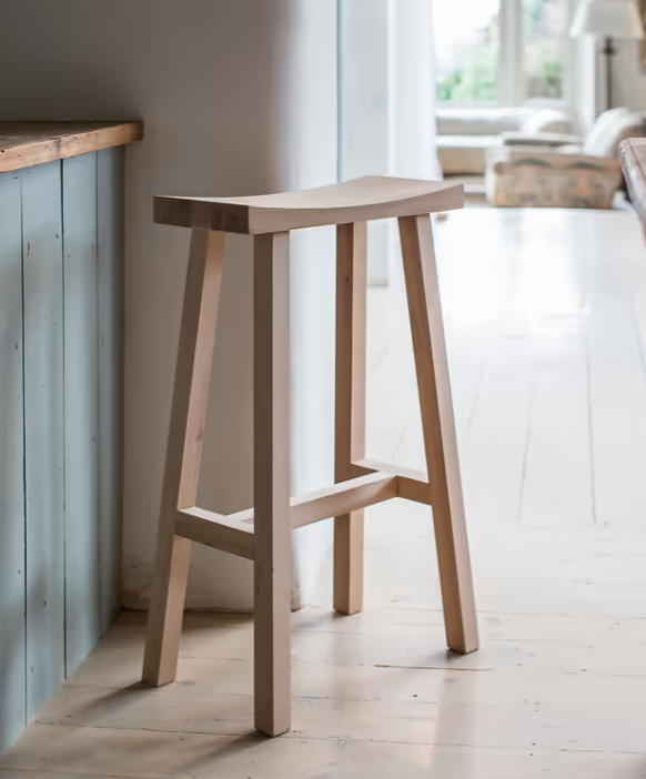 Natural oak wooden saddle stool at breakfast bar.