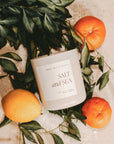 Salt and sea large soy candle in matte white jar, with oranges, leaves and salt.