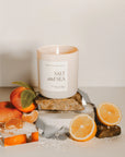 Salt and sea large soy candle in matte white jar, lit with oranges and salt.