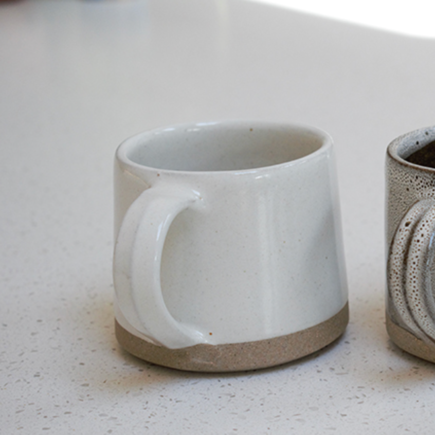handmade milk white stoneware mug with stone base.
