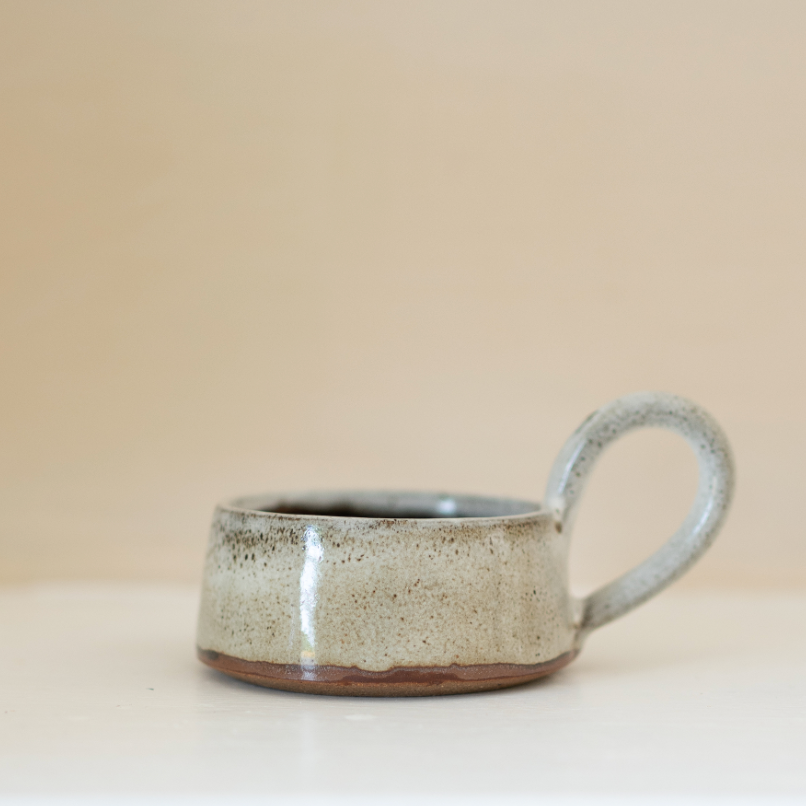 A speckled brown tealight holder with handle.