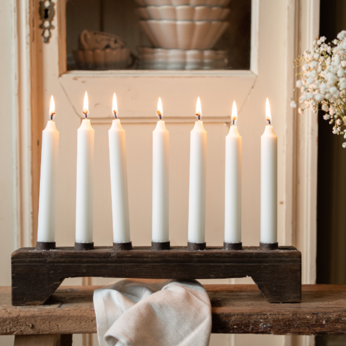  Analyzing image     Screenshot2024-02-29at13.37.17  1262 × 1262px  A wooden candle holder holding seven lit dinner candles.