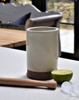 A white stoneware cocktail gift set with a lime and some ice.