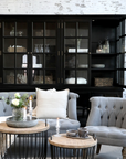 a relaxed seating area with large black armoire in background.