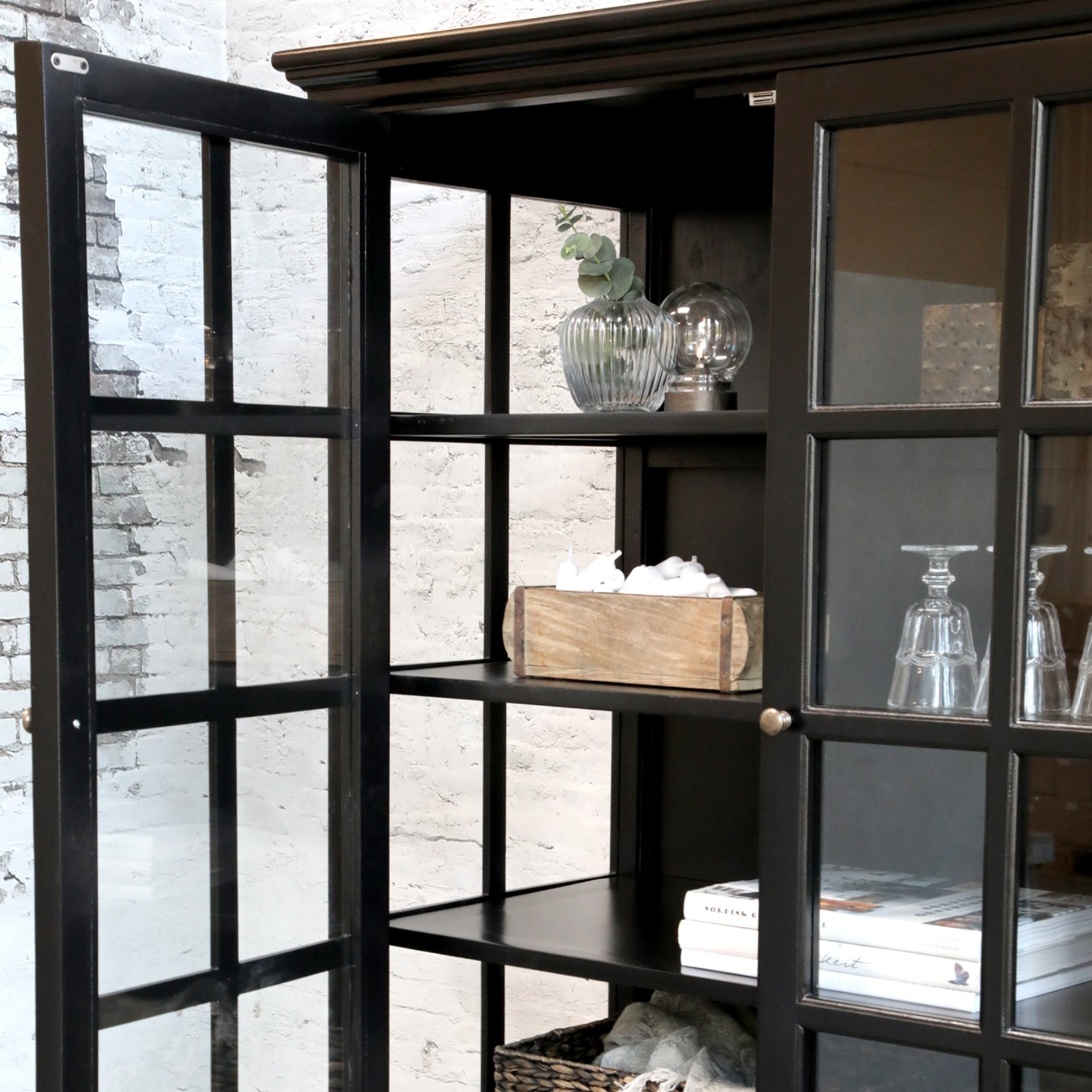 black armoire with decor items on shelves.