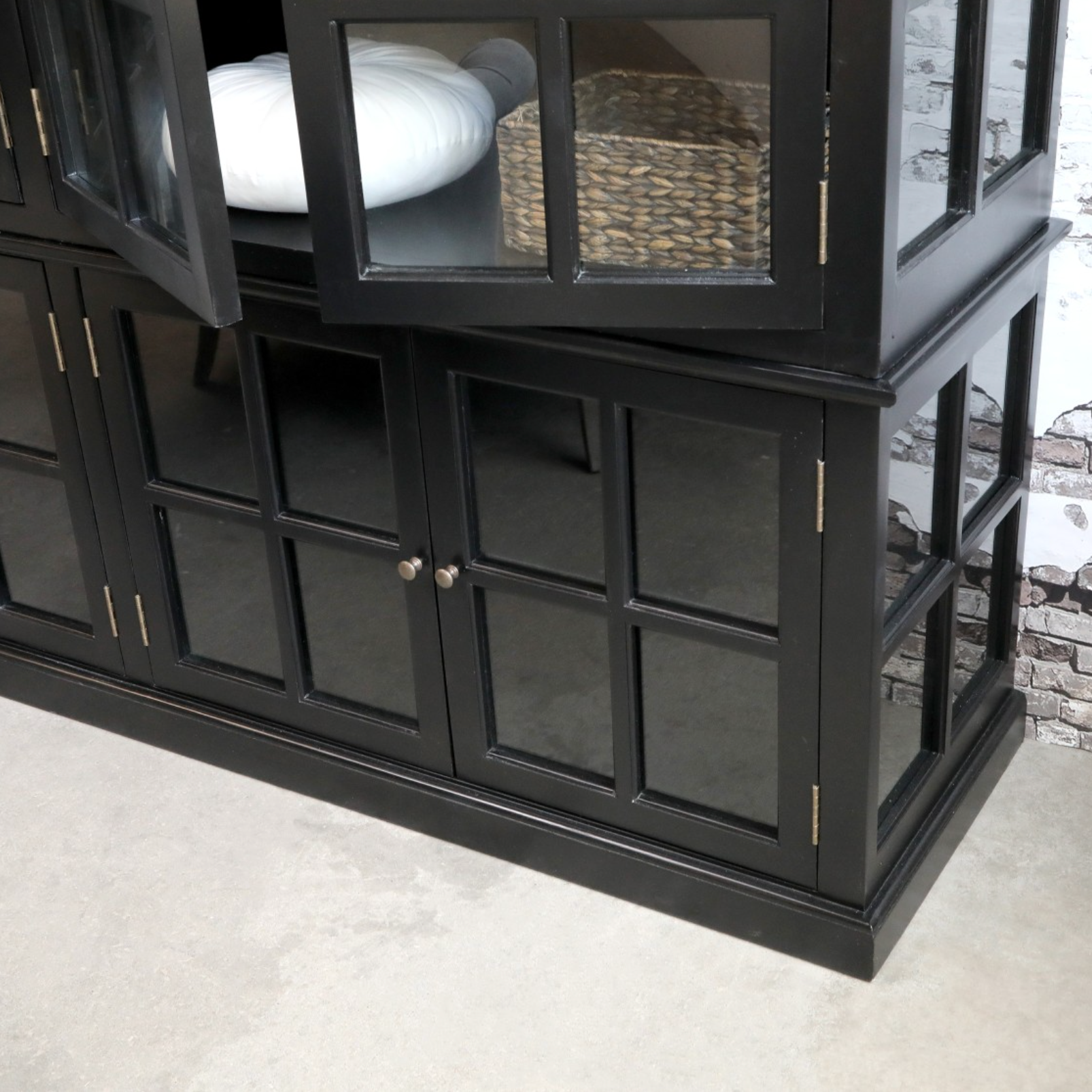 large black armoire with basket and cushion.