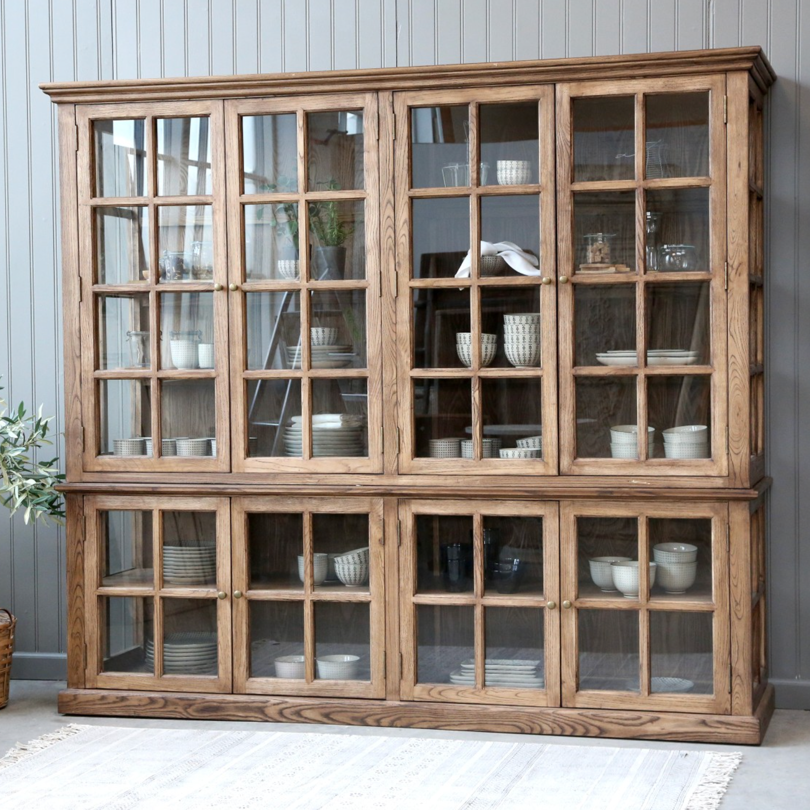 large wooden armoire displaying crockery and kitchen items. 