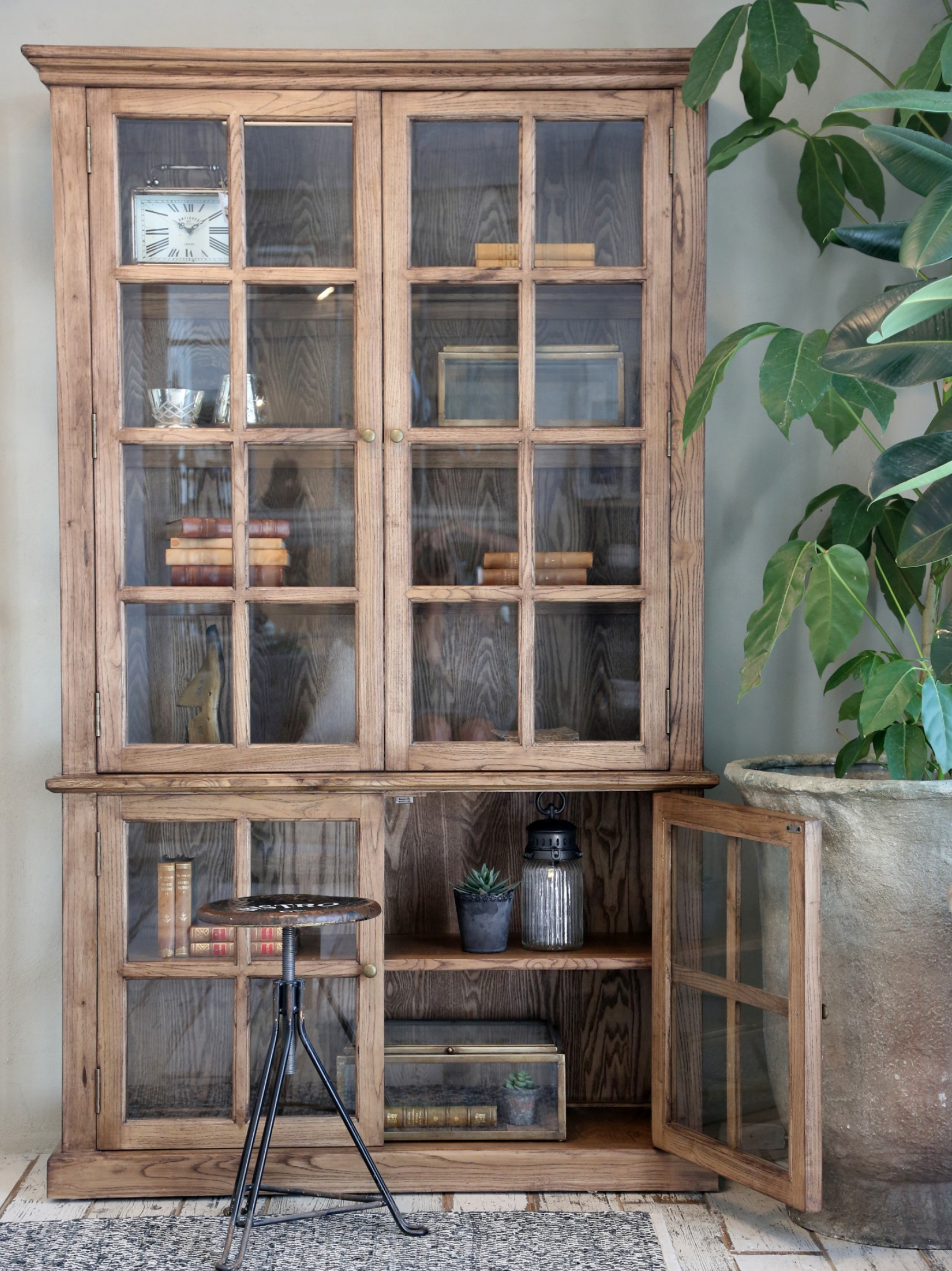 a large wooden armoire displaying books and decor items.