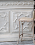 Wicker bar stool and cream ornate bar. 