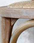 white washed detail of a wooden bar stool.