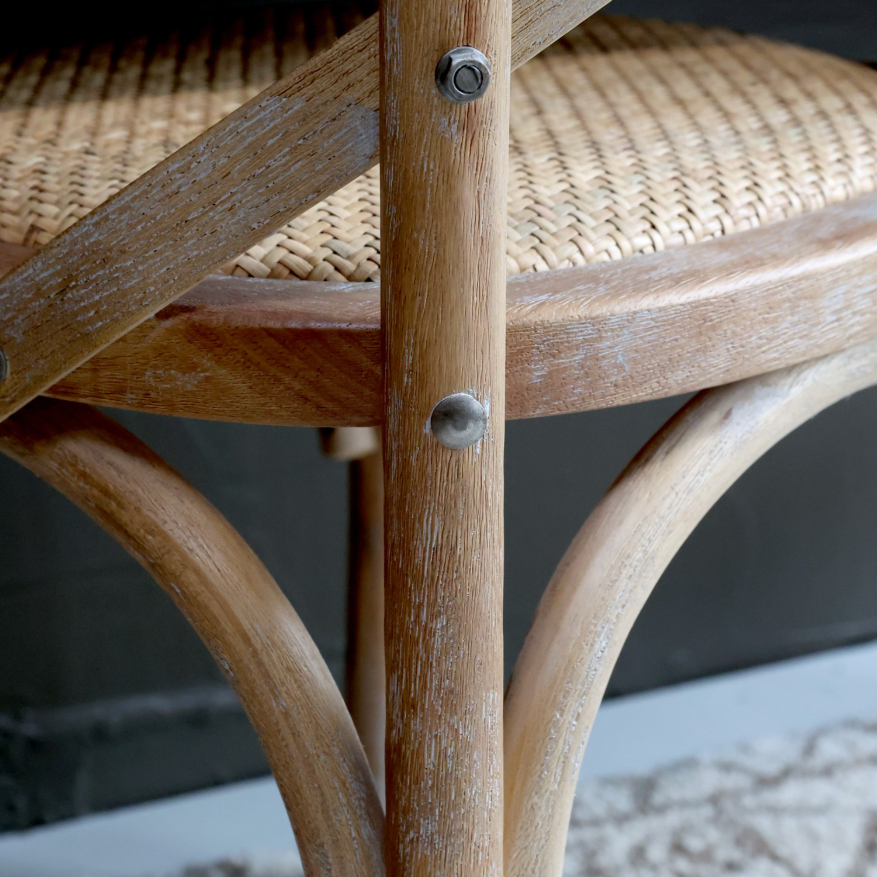 A close up image of a dining chair with wicker seat.