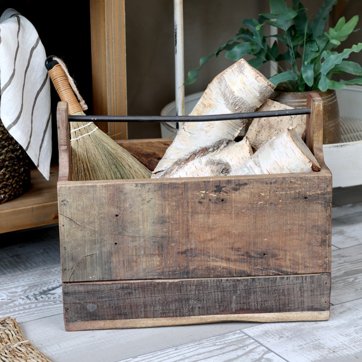 Reclaimed wooden storage box with logs and a brush.
