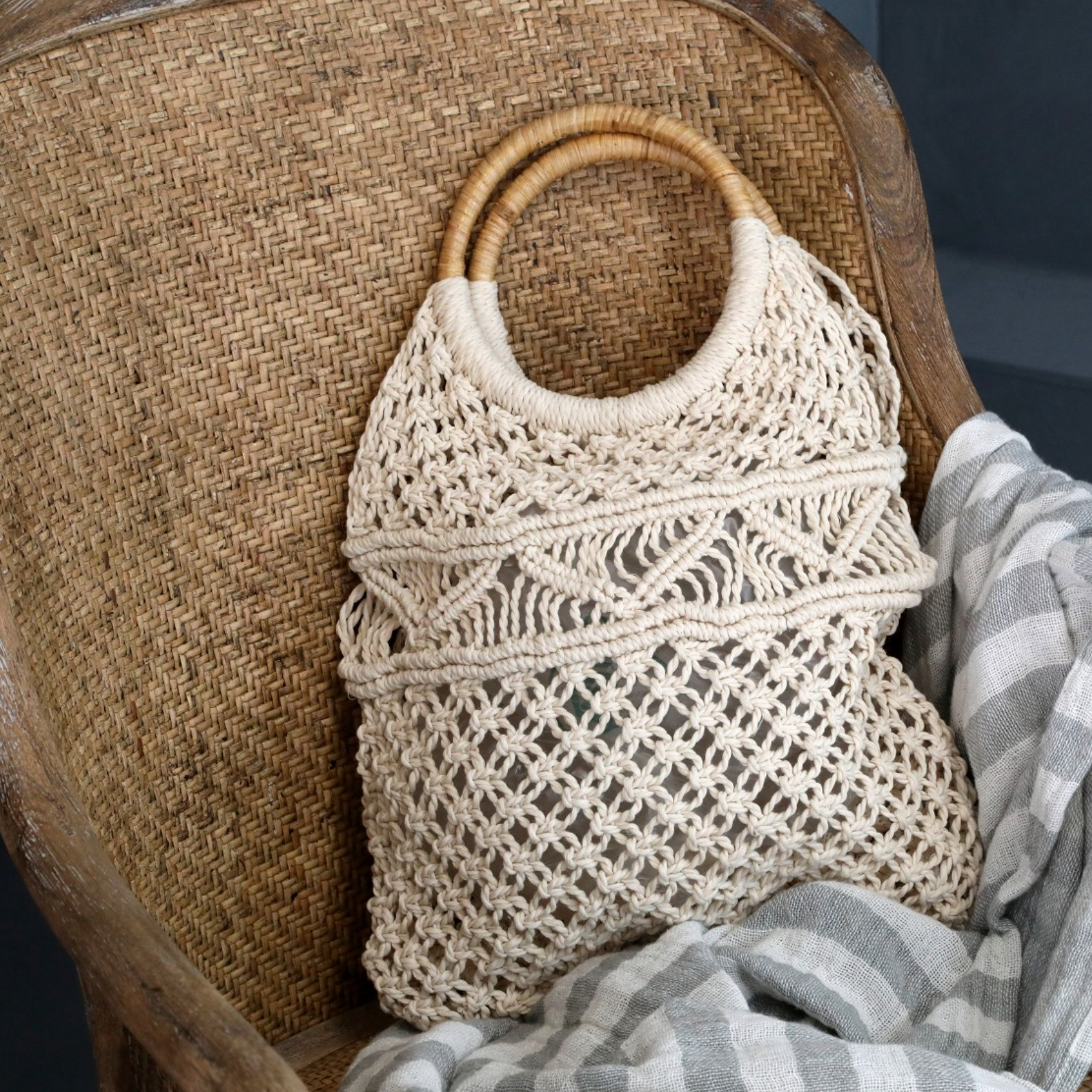 a rattan dining chair with macrame bag.
