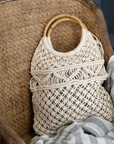 a rattan dining chair with macrame bag.