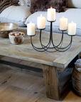 rustic wooden coffee table with candelabra and wooden bowls.