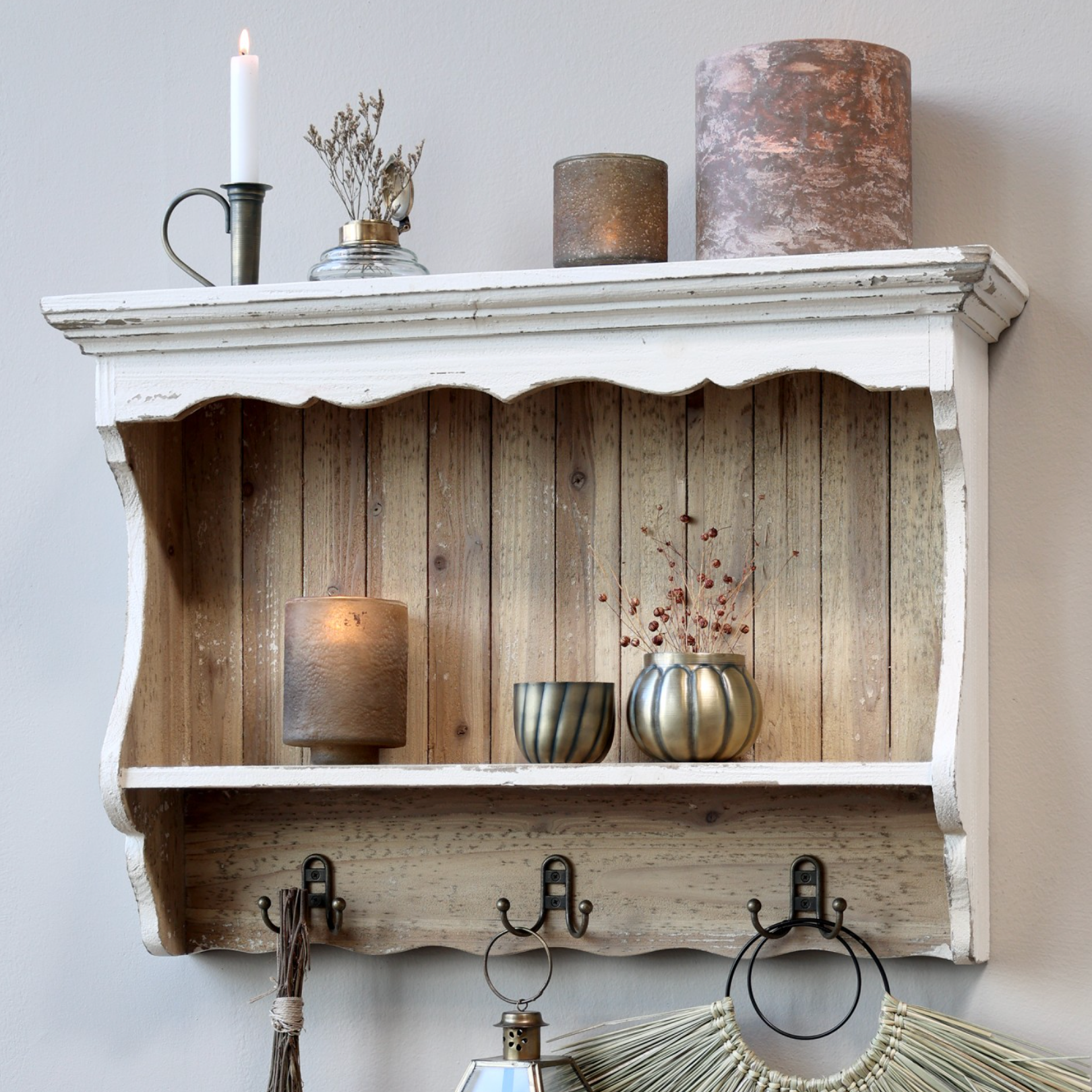 Rustic white wooden wall shelf with decor items.