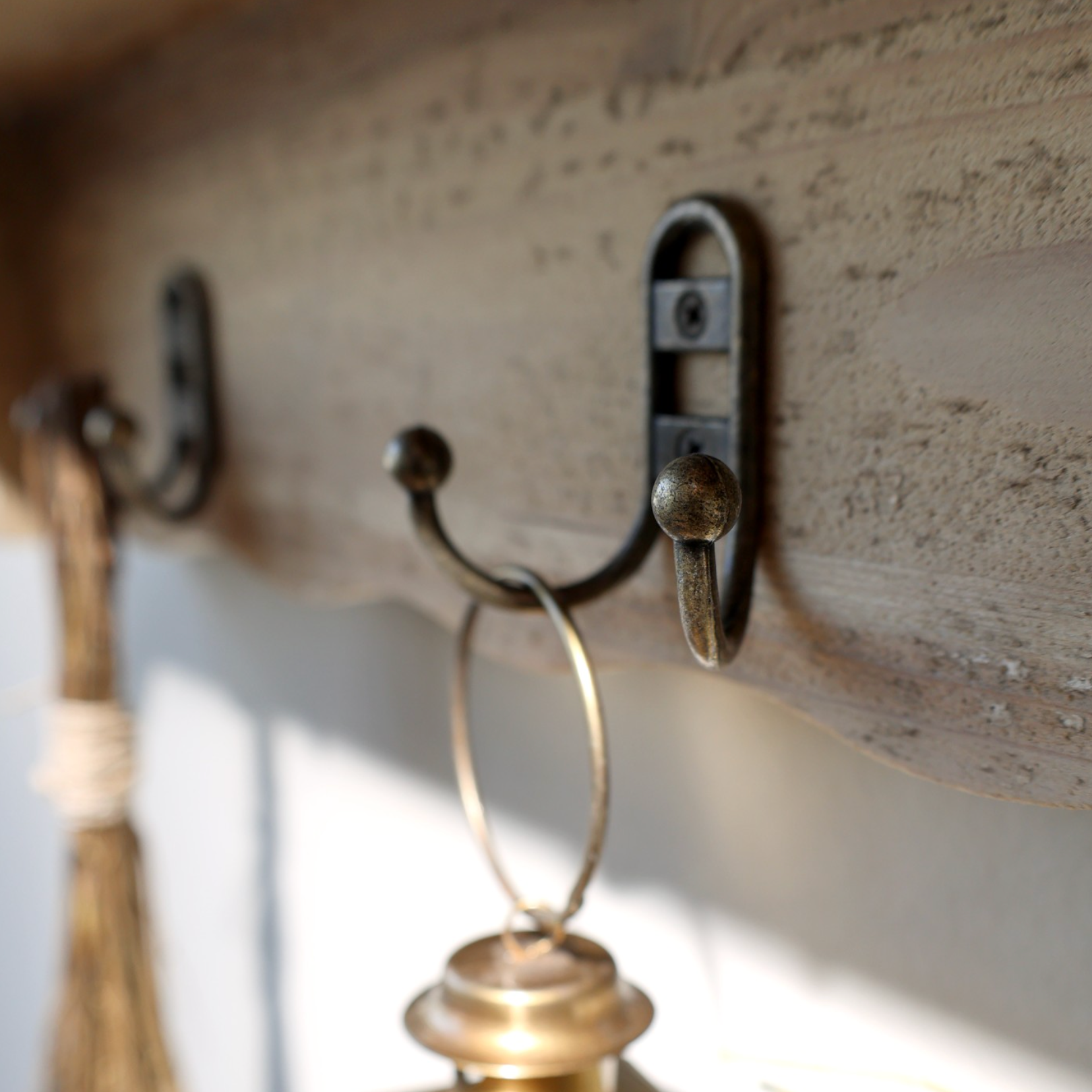 Metal hooks on wooden wall shelf.