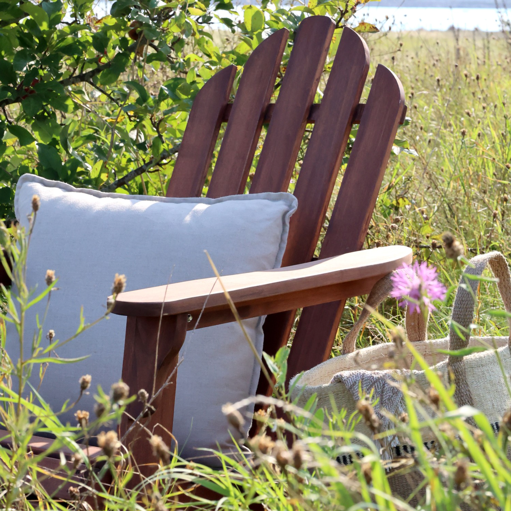 wooden outdoor armchair with white cushion.