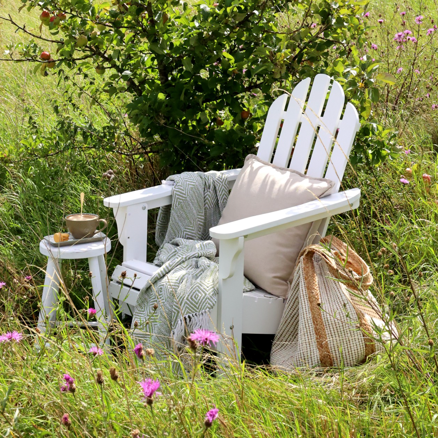 white wooden outdoor chair in field with wild flowers.