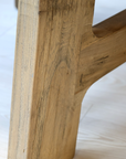 A close up of a wooden table leg.