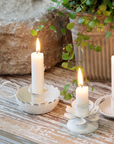 Candle Stick Holder with antique white finish and lit dinner candle.s.