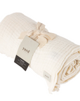 White Muslin Bedspread rolled up and tied neatly with cotton ribbon.