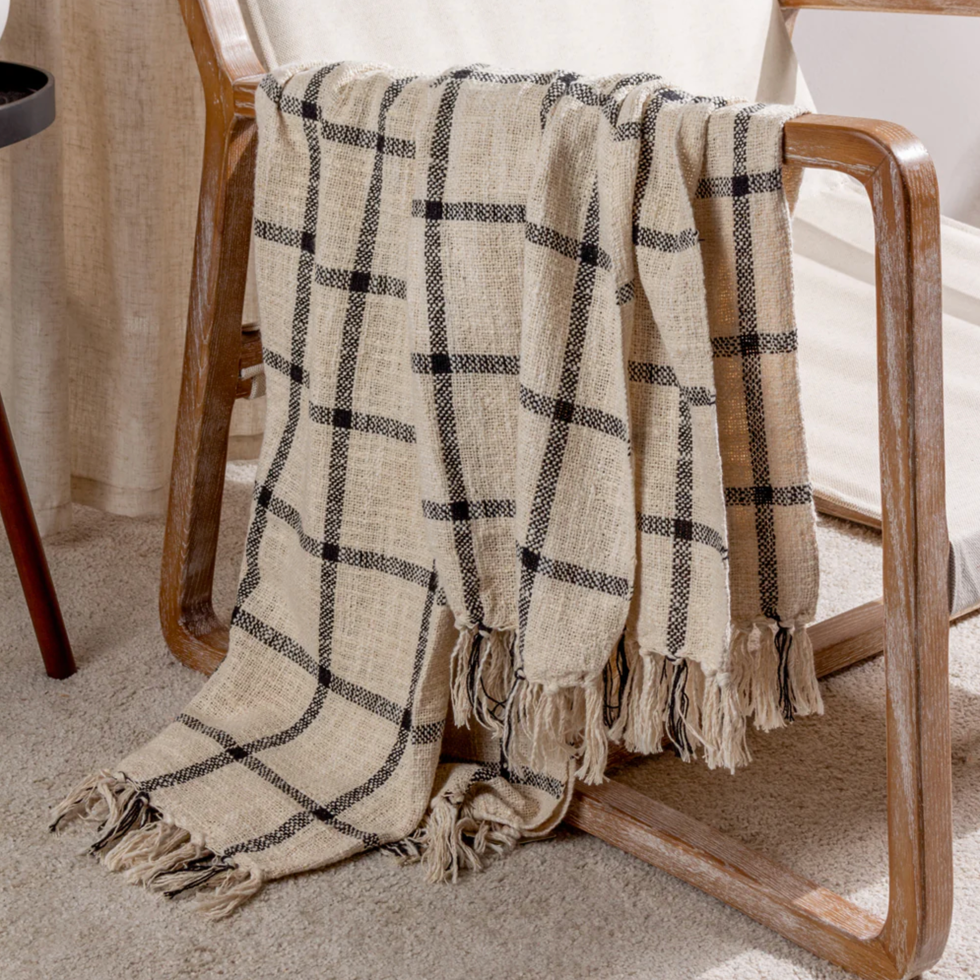 Checked Cotton Throw Blanket draped over an armchair.