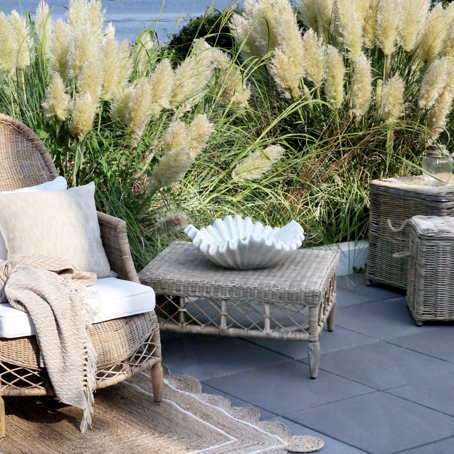 Braided rattan coffee table in outdoor living soae with pampas grass.