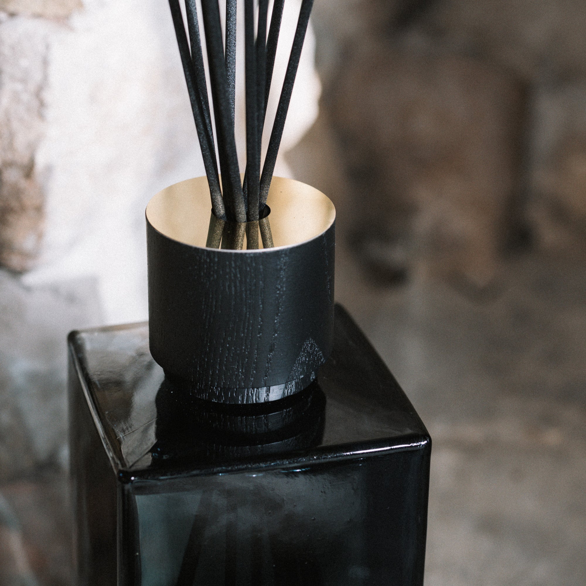 Sences Alang Alang Onyx Reed Diffuser on stone hearth.