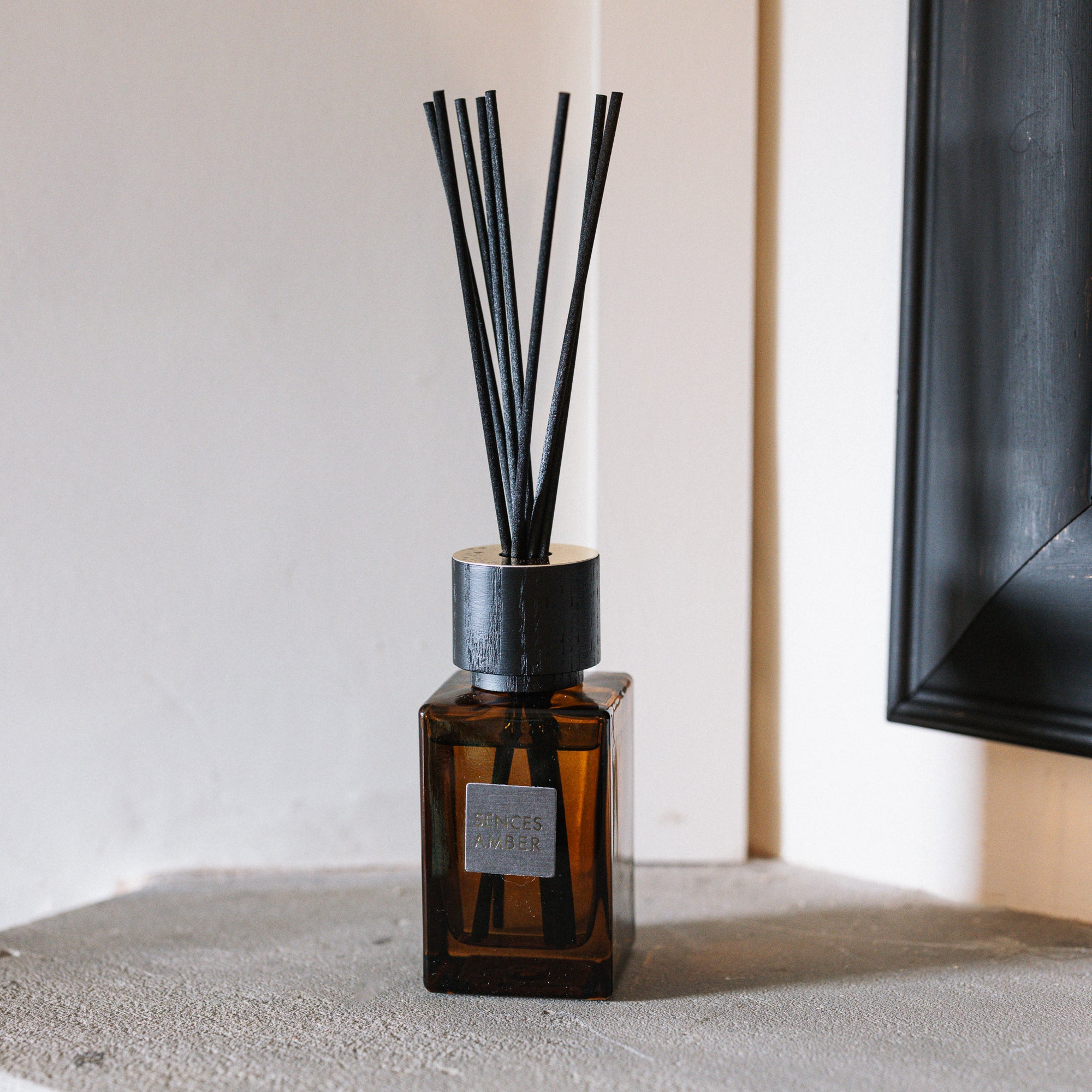 Sences Amber Mini Reed Diffuser on stone mantle.