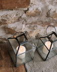 Set of two black and Glass Lanterns on stone hearth.