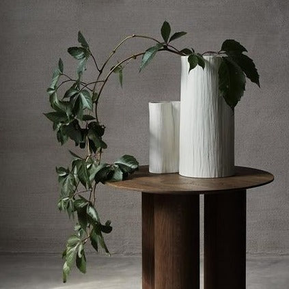 Stam cream white vase on wooden circle table.