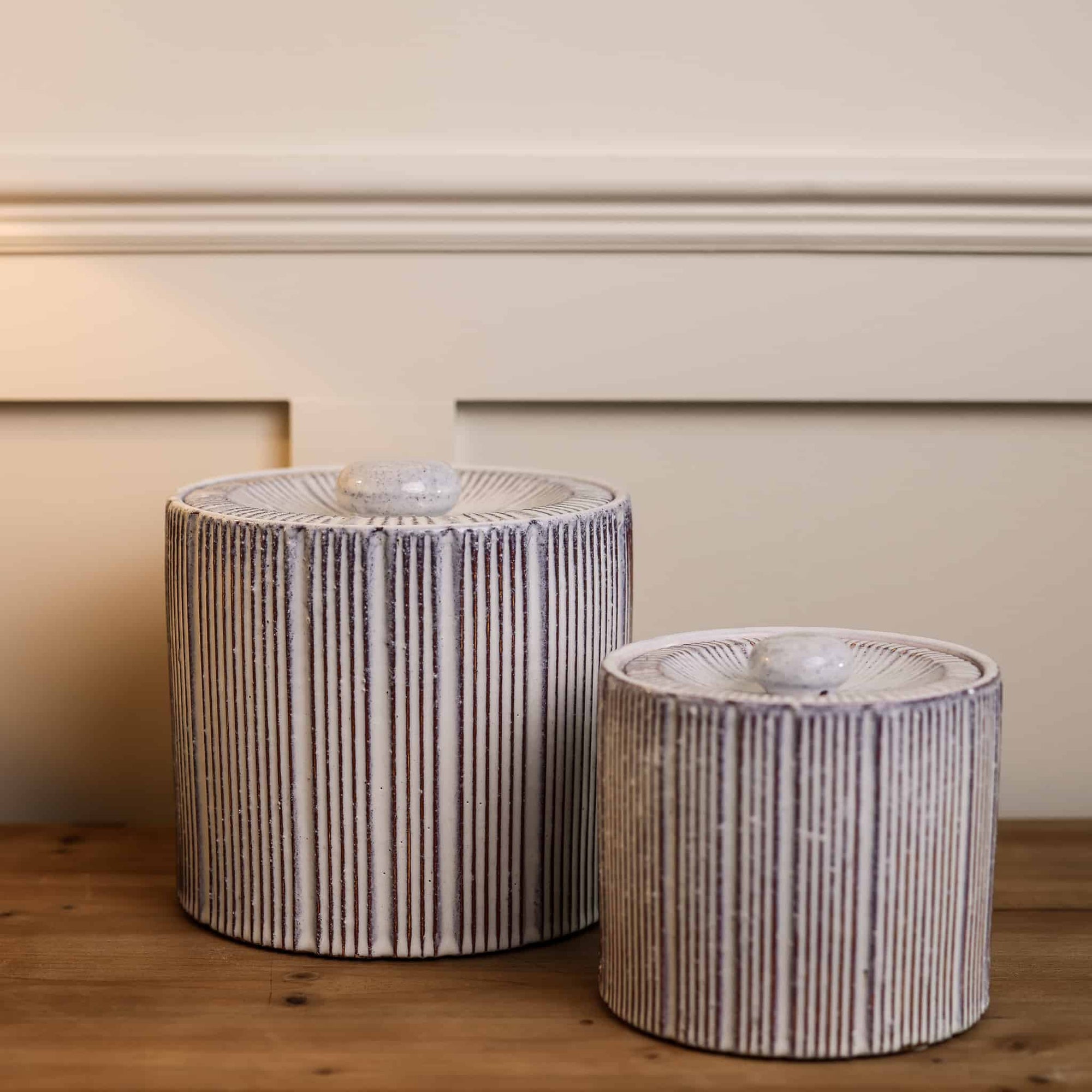 2 red and white striped ceramic storage jars.
