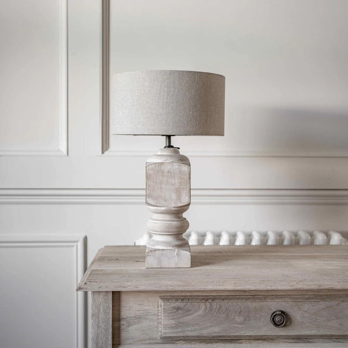a white washed mango wood lamp on wooden table.