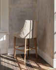  Upholstered Bar Stool With Back and blue stripe in neutral room.