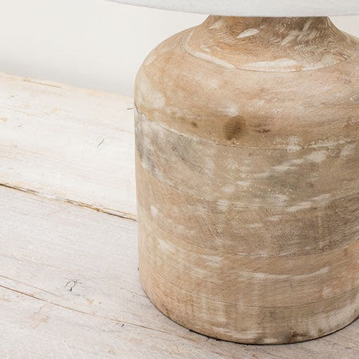 Close up of mango wood small table lamp on wooden surface.