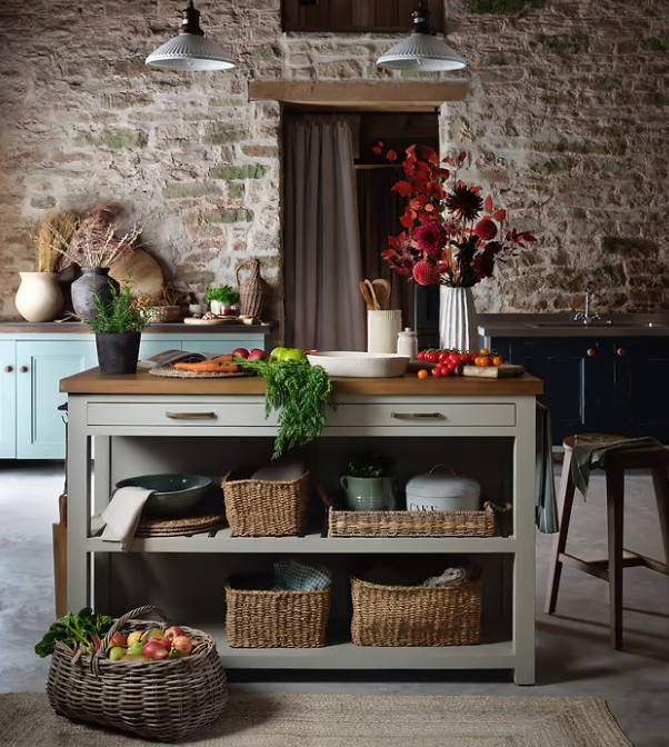 Clay painted wooden kitchen island with accessories and utensils.