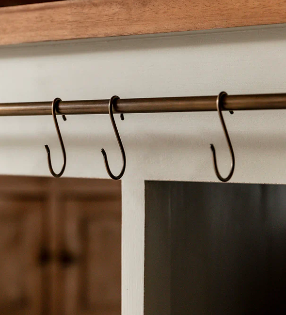 Close up of antique hooks on wooden kitchen island.