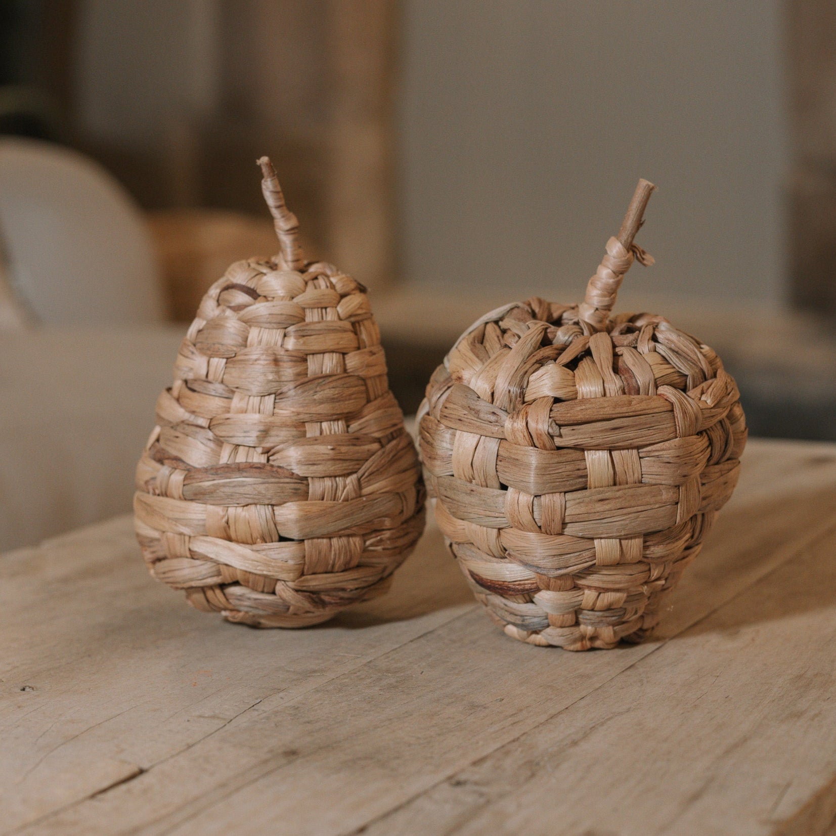 Woven Apple and Pear Ornaments on wooden coffee table.