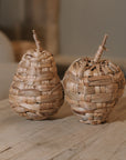 Woven Apple and Pear Ornaments on wooden coffee table.