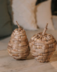 Woven Apple and Pear Ornaments on wooden table.