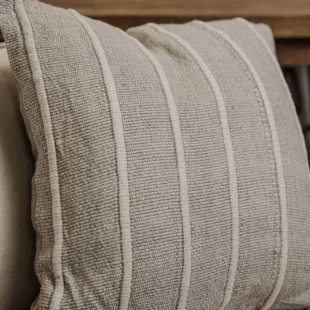 Close up of striped neutral coloured square cushion.