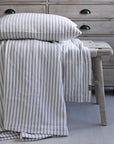 A striped cushion and blanket on bench.